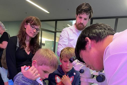 Wissenschaftler mit Kindern beim Pipettieren
