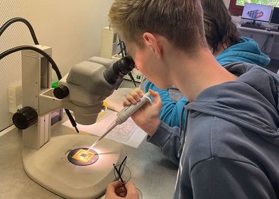 Boys´Day am BBZ: Pipettieren unterm Mikroskop. Foto: BBZ, GF Jungen im Labor an der Werkbank
